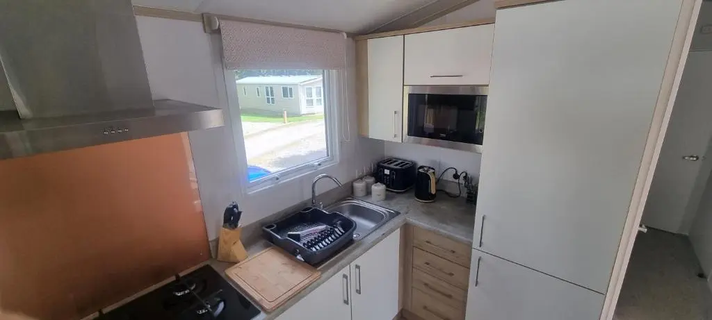 a small kitchen with a sink and a window at Lynton lodges ATLAS in Evanton