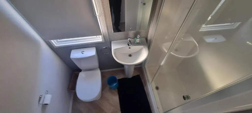 a small bathroom with a toilet and a sink at Lynton lodges ATLAS in Evanton
