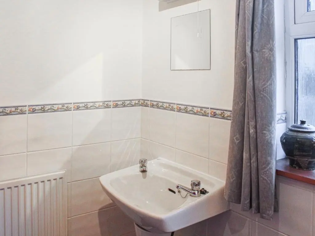 a white bathroom with a sink and a window at Pine Tree Cottage - Uk45925 in Ballater