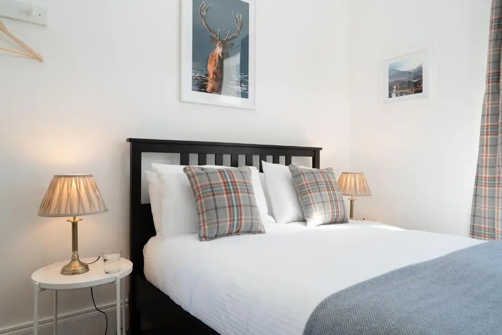 a bedroom with a bed and two lamps on tables at Nethy Station - Seasgair Lodges in Nethy Bridge
