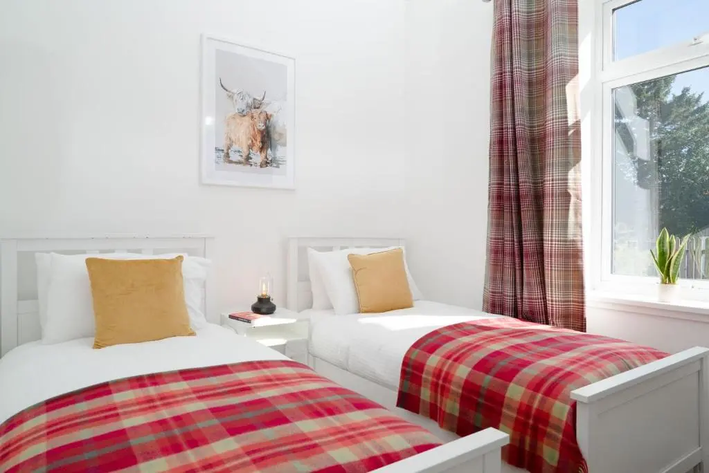 two beds sitting next to each other in a bedroom at Nethy Station - Seasgair Lodges in Nethy Bridge