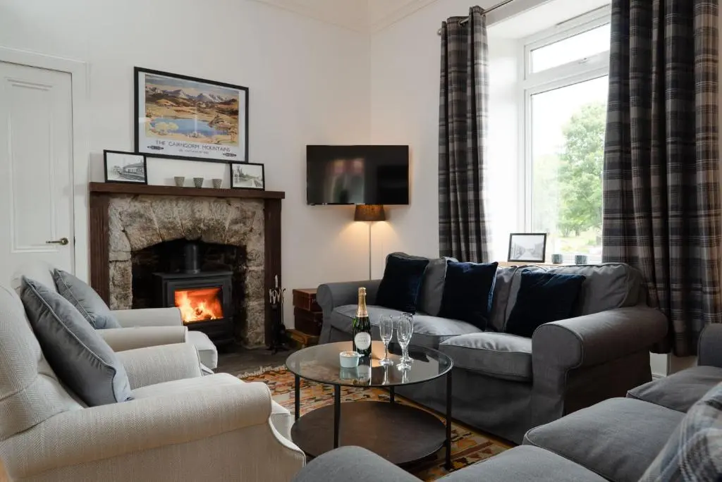 a living room with a couch and a fireplace at Nethy Station - Seasgair Lodges in Nethy Bridge