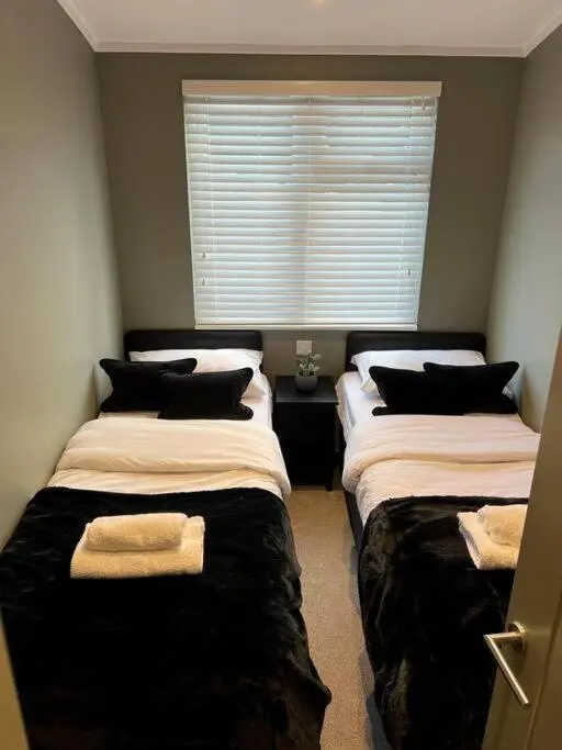 two beds in a room with a window at Luxury Lodge With Hot Tub In Royal Deeside in Strachan