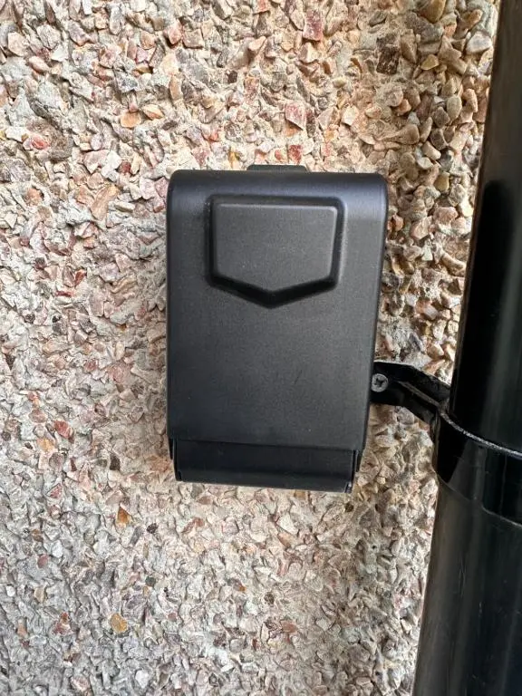 a black mailbox sitting on a stone wall at Apartment in Queens Court, Banchory in Inchmarlo
