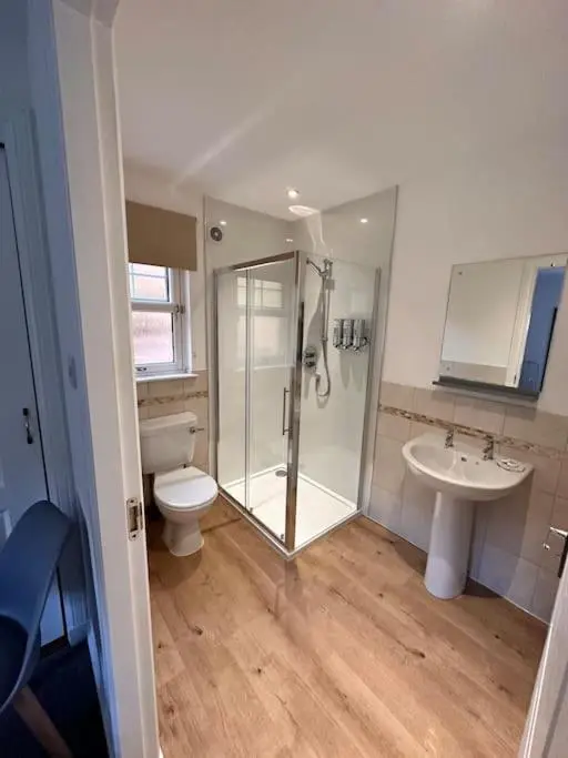 a bathroom with a shower and a toilet and a sink at Apartment in Queens Court, Banchory in Inchmarlo