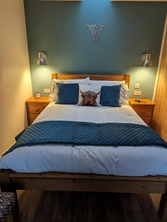 a dog sitting on top of a bed at The Coo Shed in Inverness