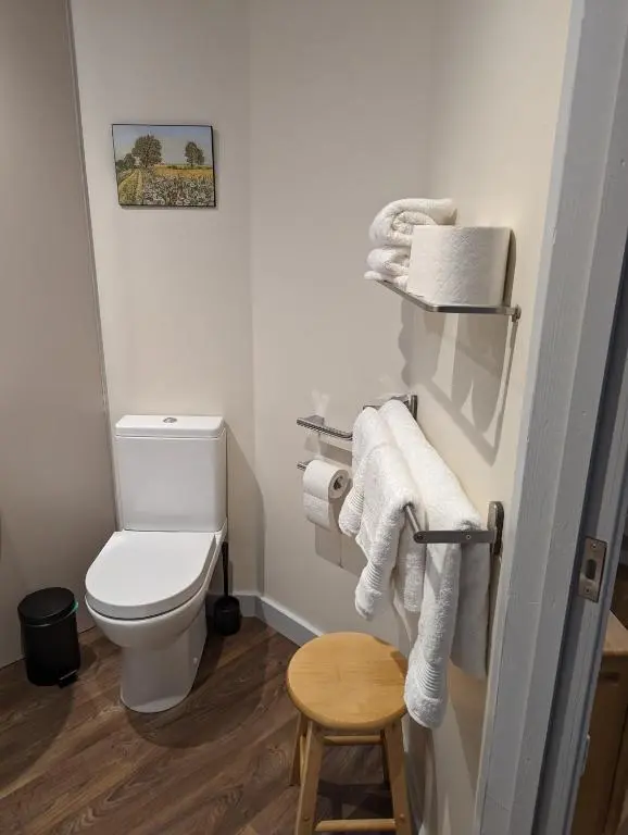 a small bathroom with a toilet and towels at The Coo Shed in Inverness