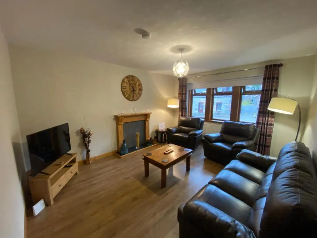 a living room with a couch and a fireplace at Lyngarrie in Dufftown