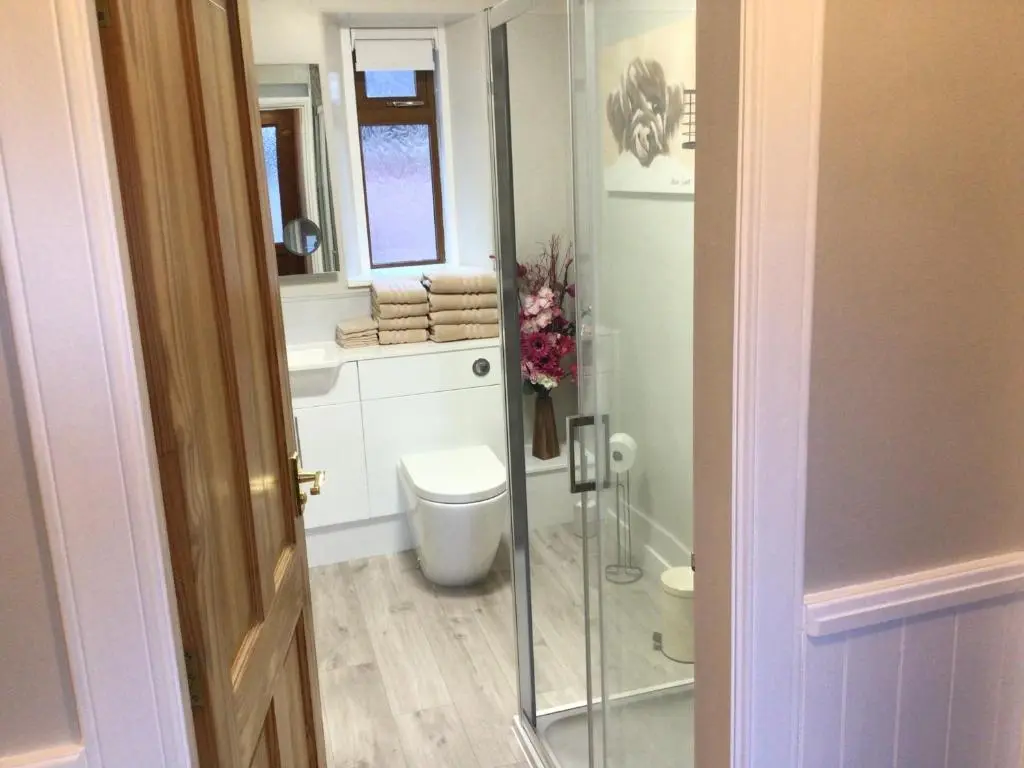 a bathroom with a toilet and a glass shower at Lyngarrie in Dufftown