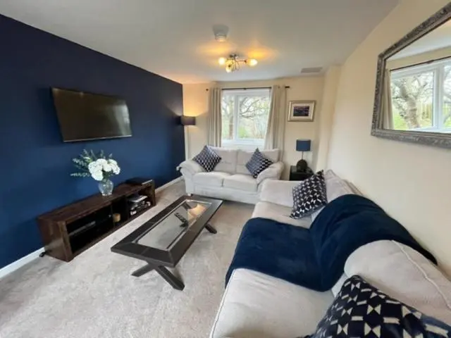 a living room with a couch and a tv at Above the harbour wick in Wick