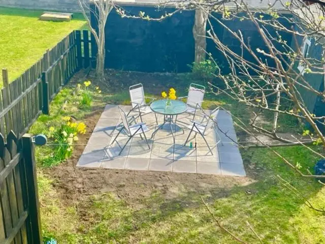 a table and chairs in a yard with a fence at Above the harbour wick in Wick