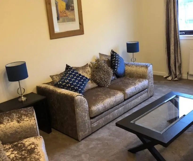 a living room with a couch with pillows on it at Above the harbour wick in Wick