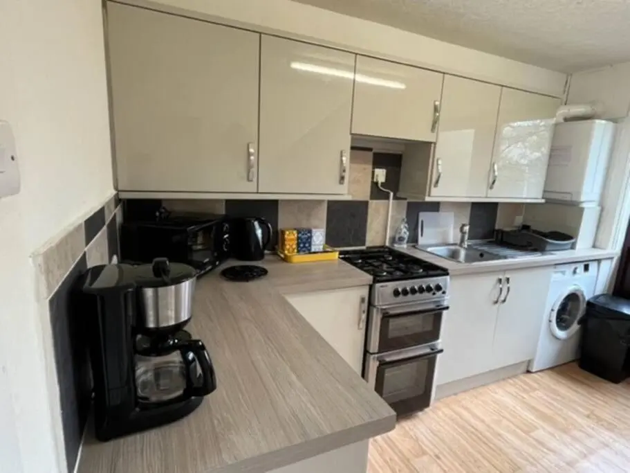 a kitchen with white cabinets and a counter top at Above the harbour wick in Wick