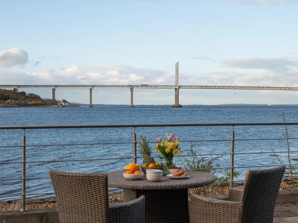 a table with fruit and flowers on it next to a bridge at 2 Bed in South Kessock CA324 in Inverness