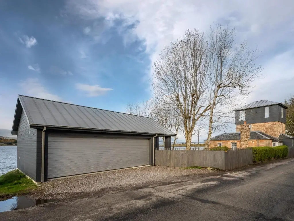 a building with a garage on the side of a street at 2 Bed in South Kessock CA324 in Inverness