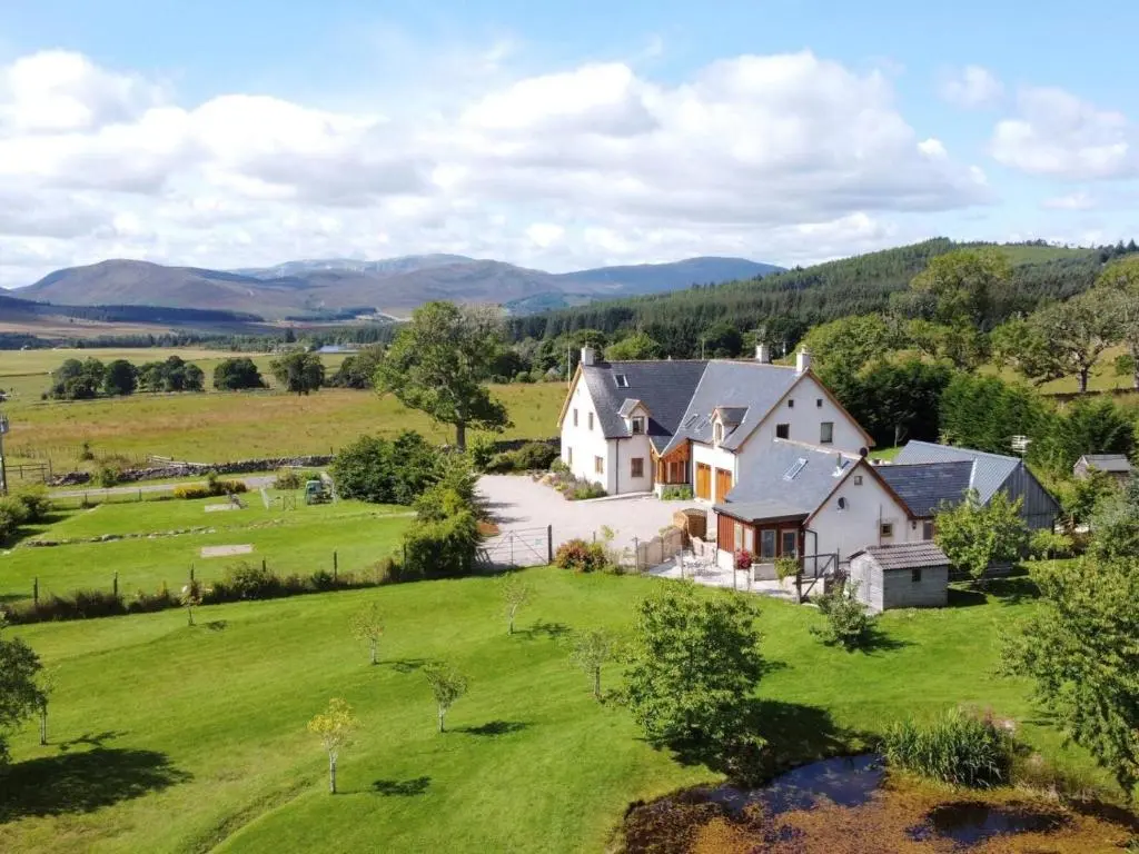an aerial view of a large white house on a green field at 2 Bed in Ardross oc-ca384 in Stittenham