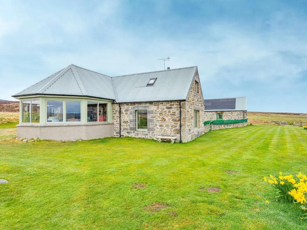 a stone house in a field with a large yard at 4 Bed in Grantown-on-Spey CA383 in Aitnoch