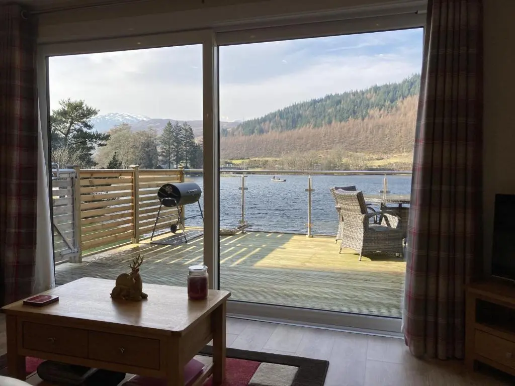 a living room with a view of a large window at Lodge 24 in Spean Bridge