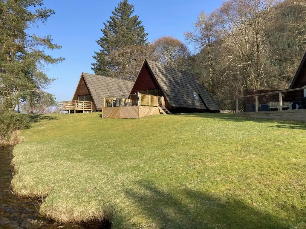 a large grassy field in front of a barn at Lodge 24 in Spean Bridge
