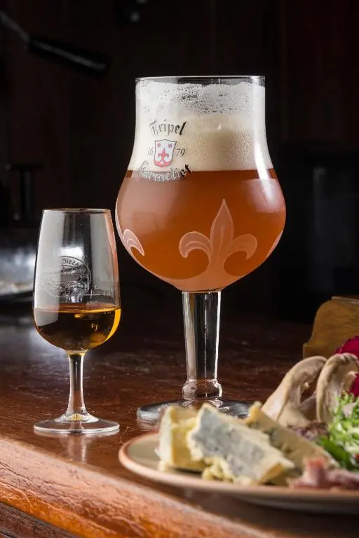 a glass of beer and a plate of food on a table at The Anderson in Fortrose