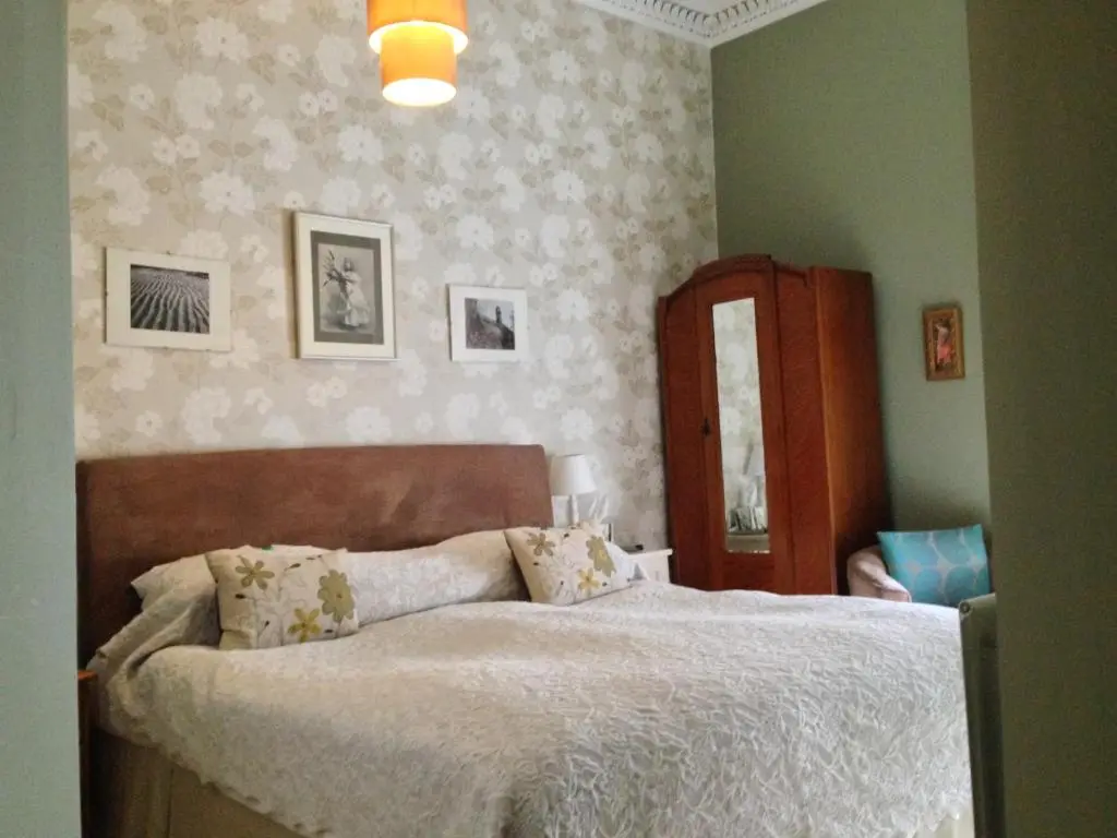 a bedroom with a bed and a dresser and a mirror at The Anderson in Fortrose