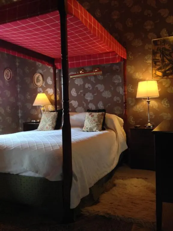 a bedroom with a bed with a red canopy at The Anderson in Fortrose