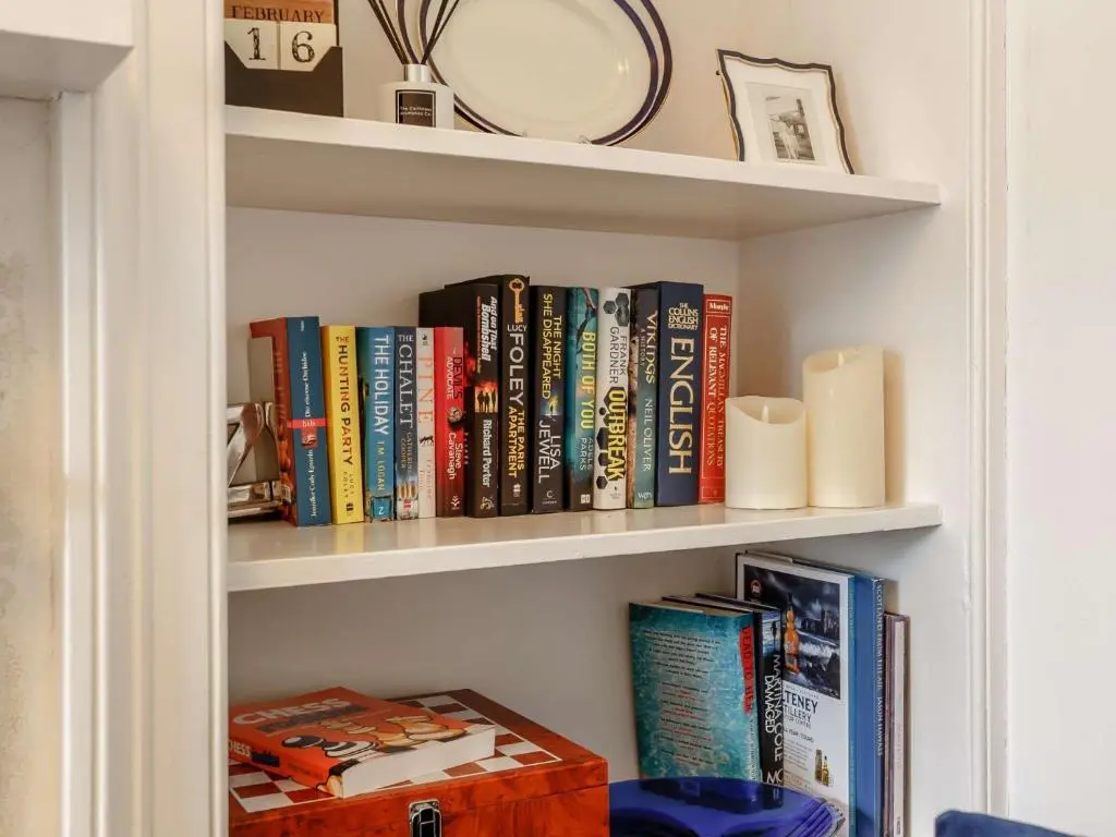 a book shelf filled with books and a plate at 4 Bed in Wick 91390 in Wick
