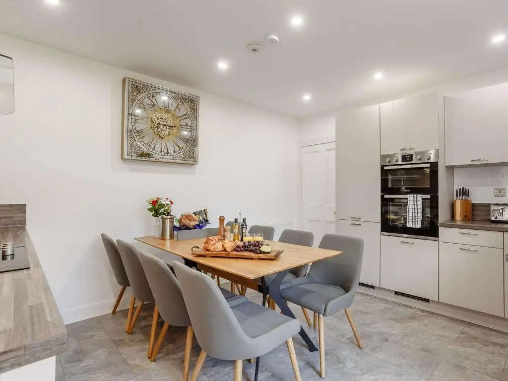 a kitchen and dining room with a wooden table and chairs at 4 Bed in Wick 91390 in Wick
