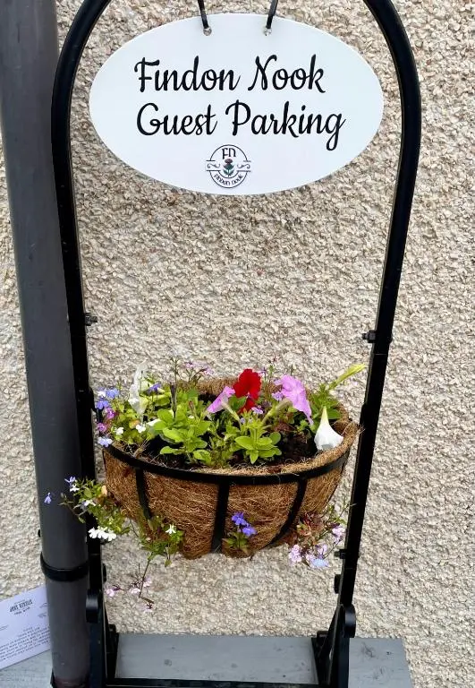 a flower pot sitting on a wrought iron rack at Findon Nook in Culbokie