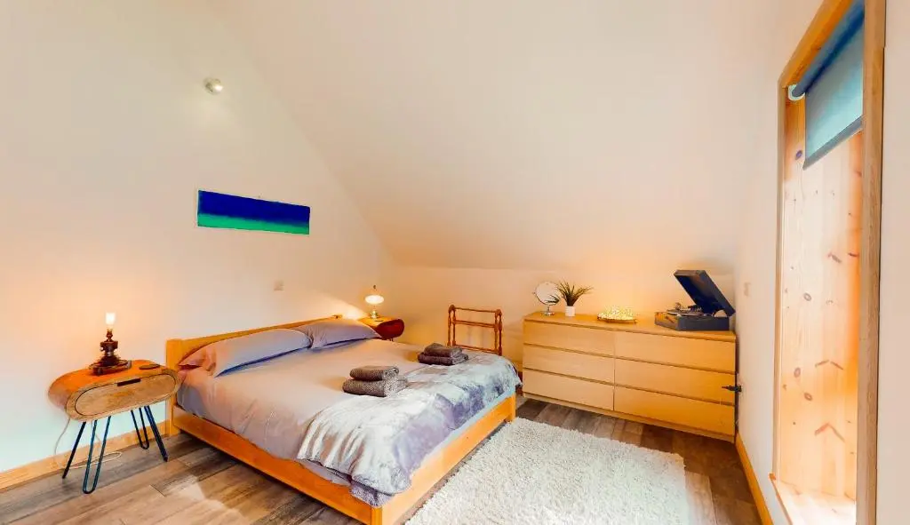 a bedroom with a bed and a desk and a tv at Woodhaus Aviemore Lodge in Aviemore