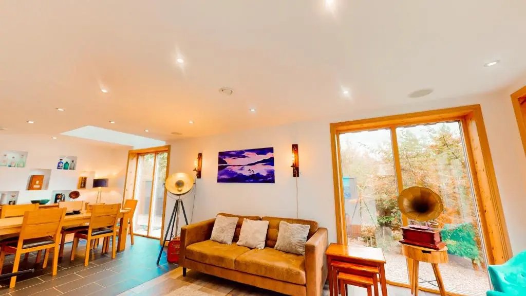 a living room with a couch and a table at Woodhaus Aviemore Lodge in Aviemore