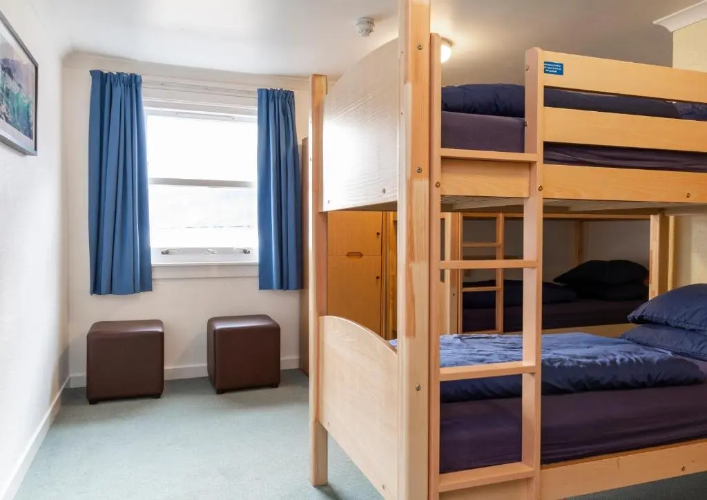 a bunk bed room with two bunk beds and a window at Ullapool Youth Hostel in Ullapool