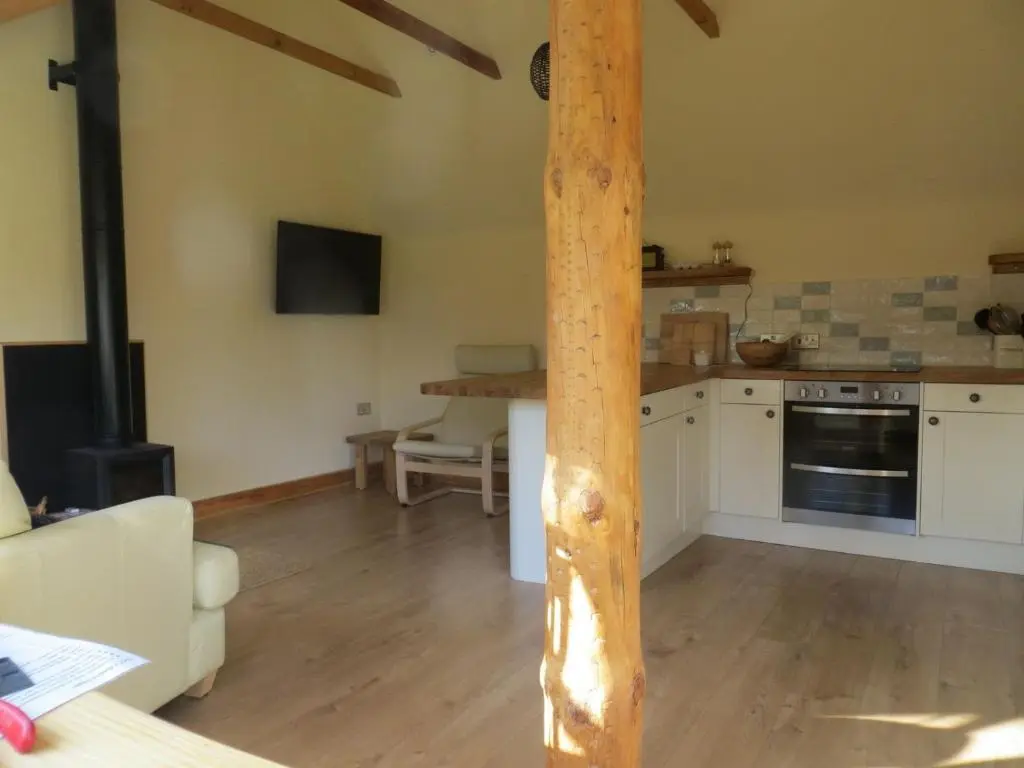 a kitchen with a wooden pole in a room at Sycamore Cottage in Boat of Garten