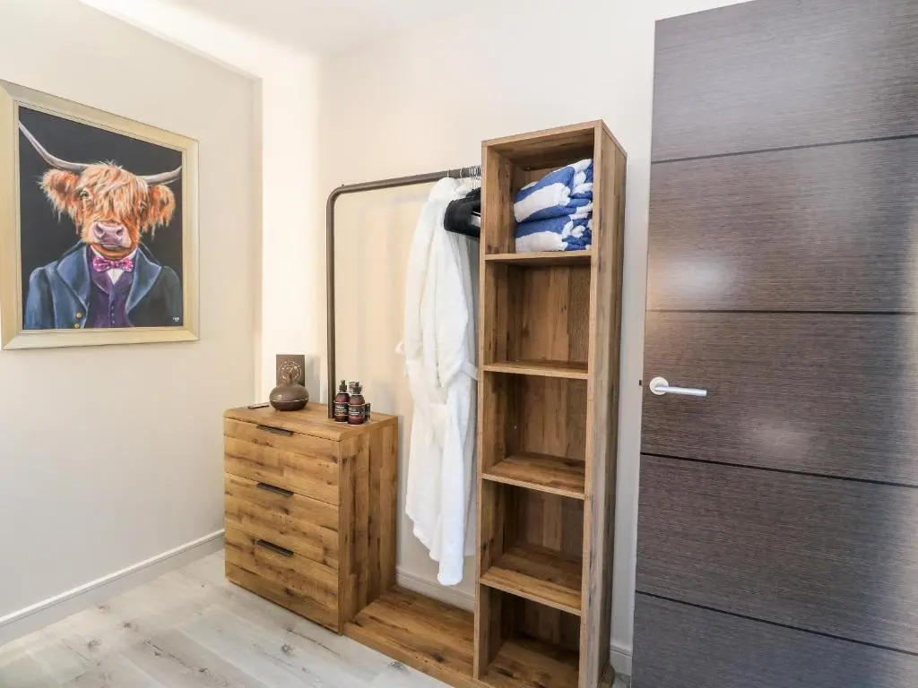 a room with a closet with a wooden cabinet at Heilan Roo in Pitlochry