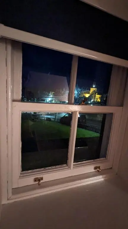 a window with a view of a city at night at Historic character cottage in central Dornoch in Dornoch