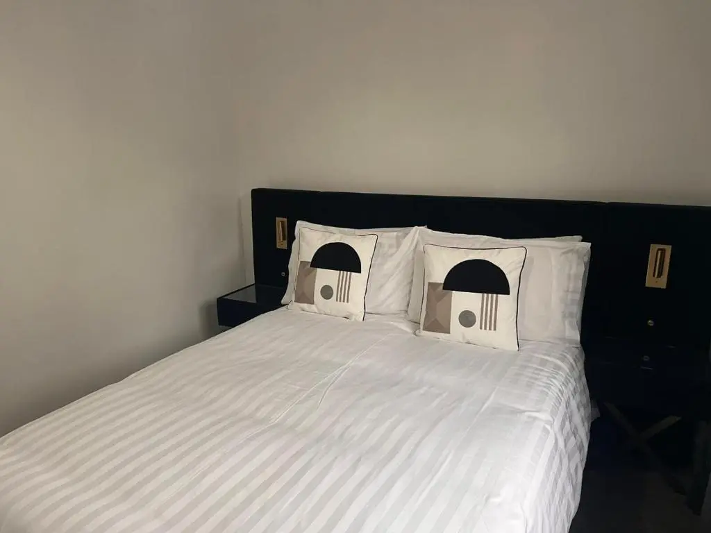 a bed with white sheets and pillows in a bedroom at Shared House in Inverness in Inverness