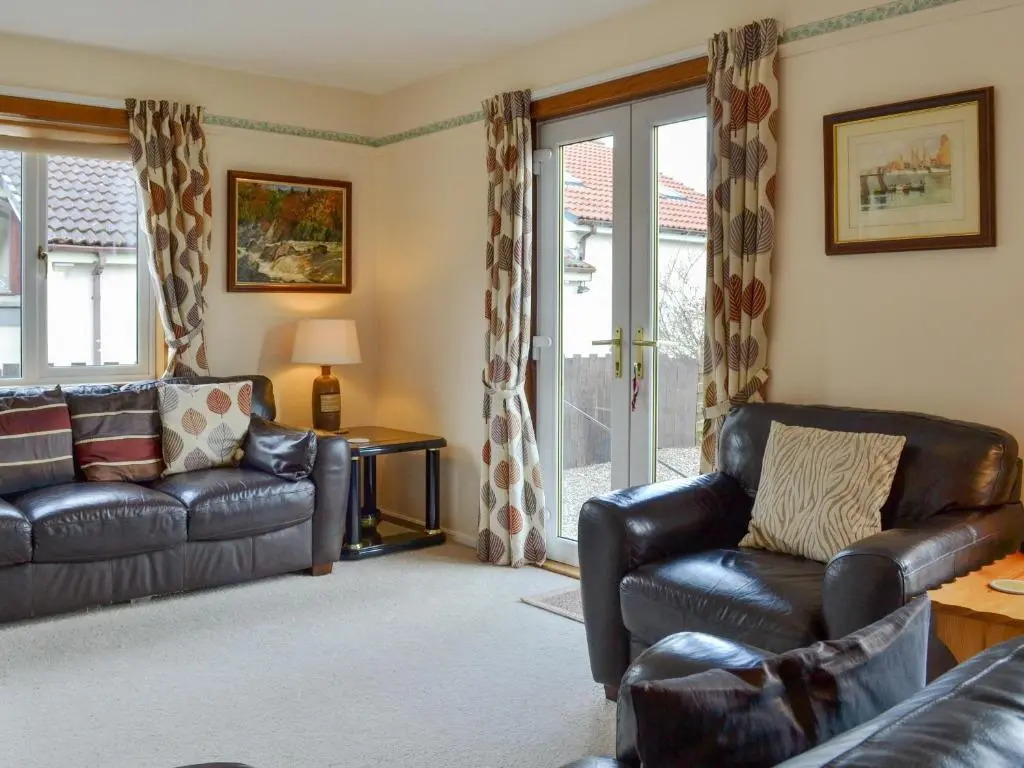 a living room with a couch and a chair at Cedar Cottage - Uk32633 in Grantown on Spey