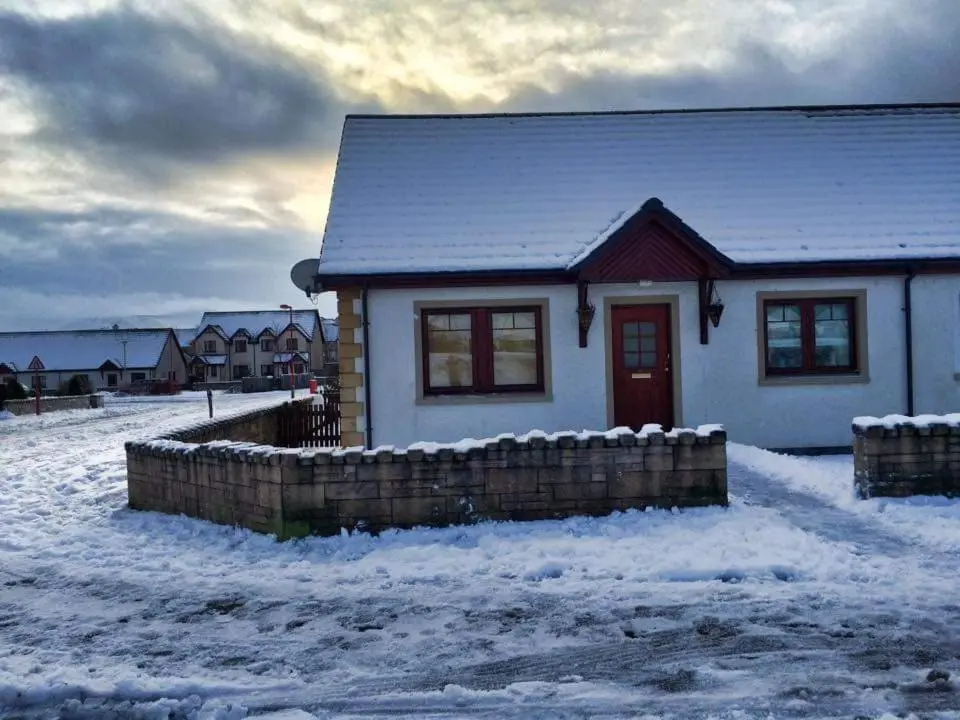 a house in the snow with a fence at Mountain View No12 in Aviemore