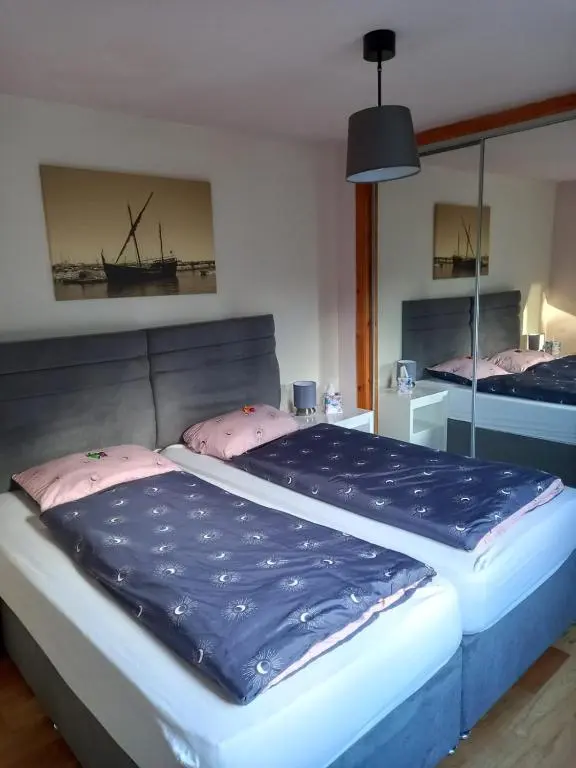 a bedroom with a large bed with blue sheets and pink pillows at The Boathouse in Longmorn