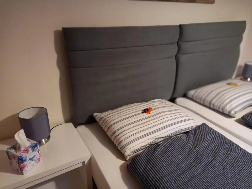 a bed with a striped pillow on top of it at The Boathouse in Longmorn