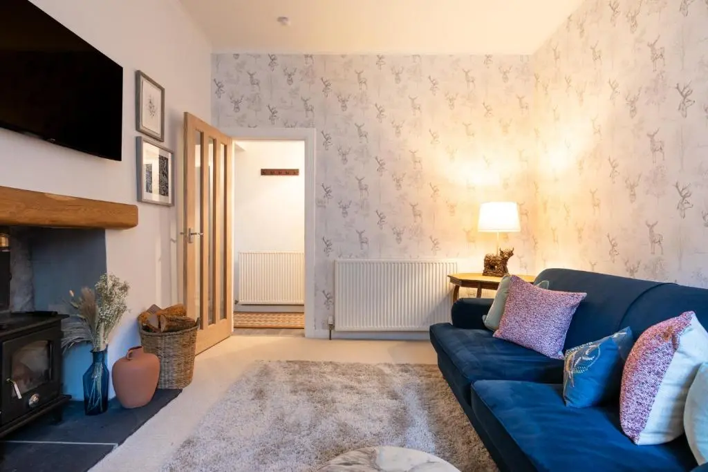 a living room with a blue couch and a fireplace at The Tartan Terrace in Inverness