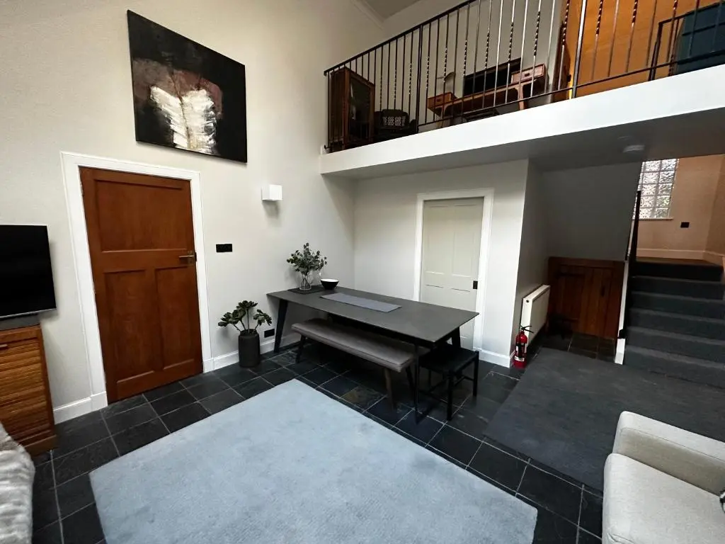 a living room with a table and a staircase at Findhorn Lodge in Findhorn