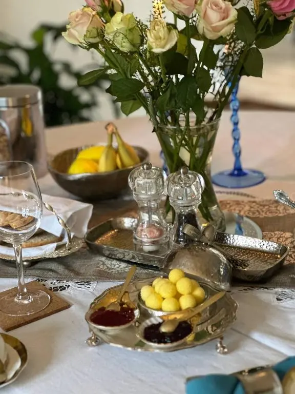 a table with a vase of flowers and plates of food at Awakening Alchemy Retreat Centre in Inverurie