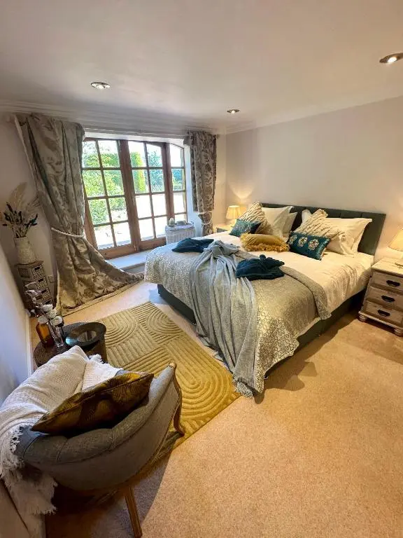 a large bedroom with two beds and a window at Awakening Alchemy Retreat Centre in Inverurie