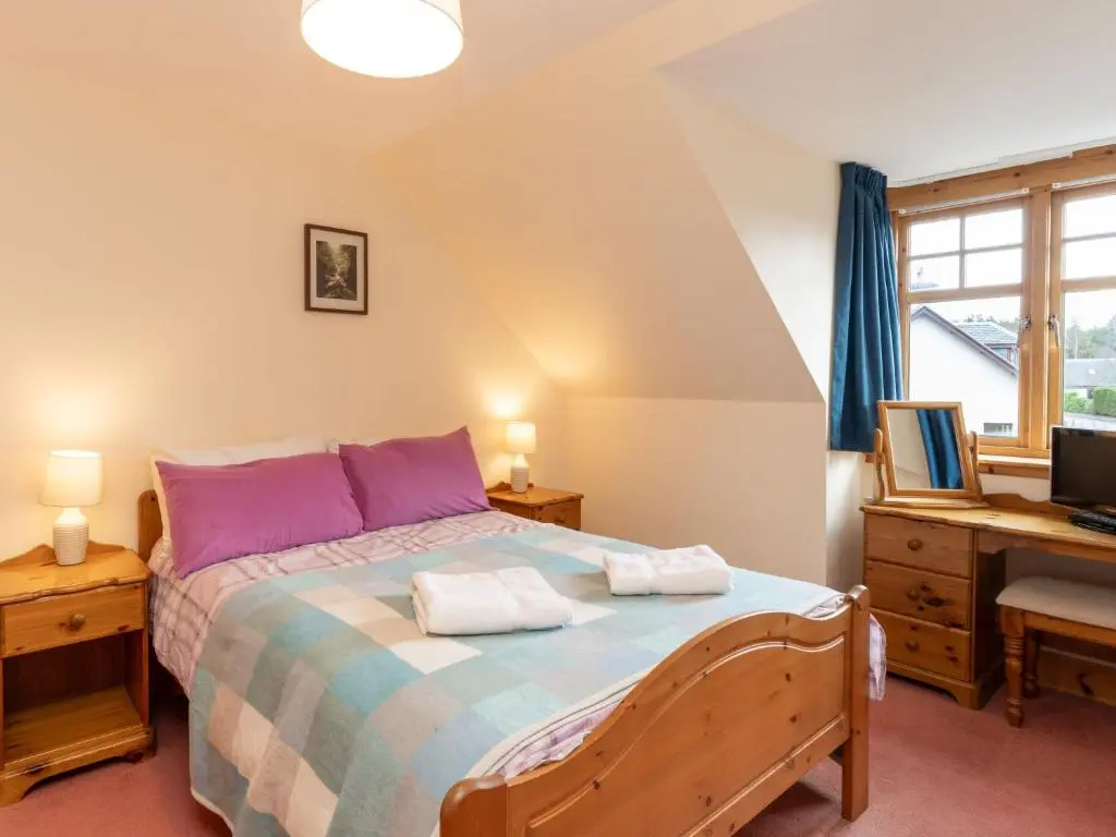 a bedroom with a bed and a desk at Villa Osprey House by Interhome in Nethy Bridge