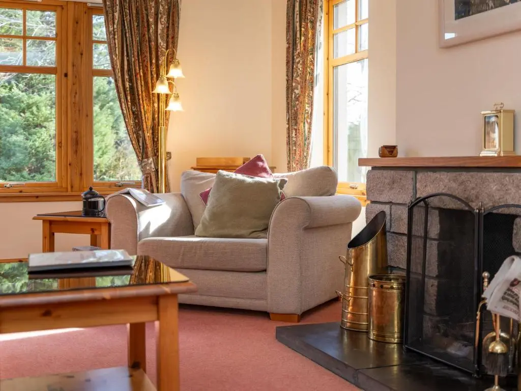 a living room with a couch and a fireplace at Villa Osprey House by Interhome in Nethy Bridge