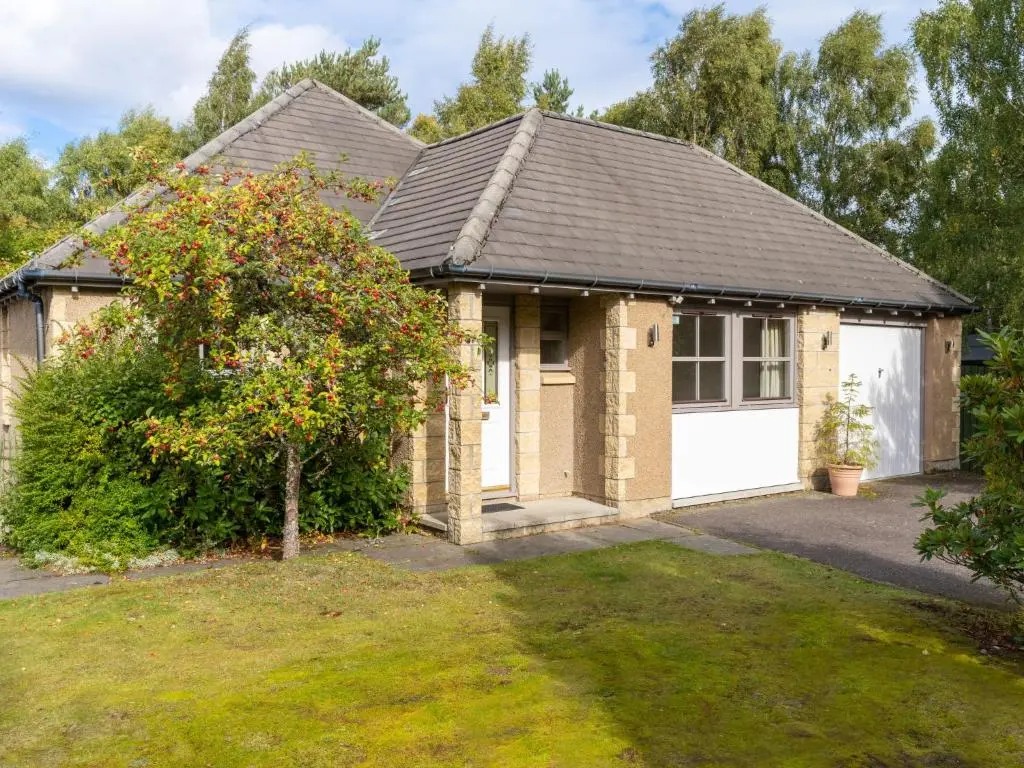 a house with a garage and a tree at Holiday Home Falcon Lodge by Interhome in Aviemore