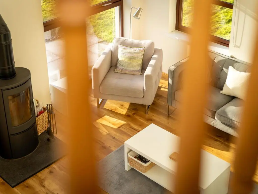a living room with a chair and a fireplace at Villa Pineways by Interhome in Aviemore