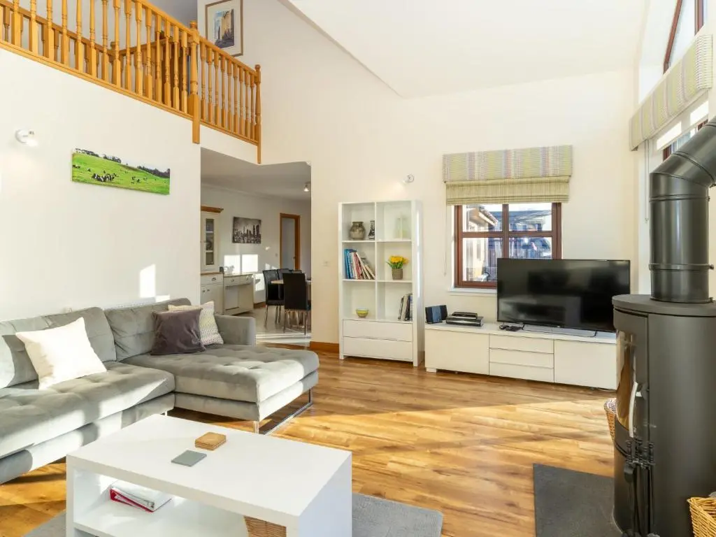 a living room with a couch and a tv at Villa Pineways by Interhome in Aviemore
