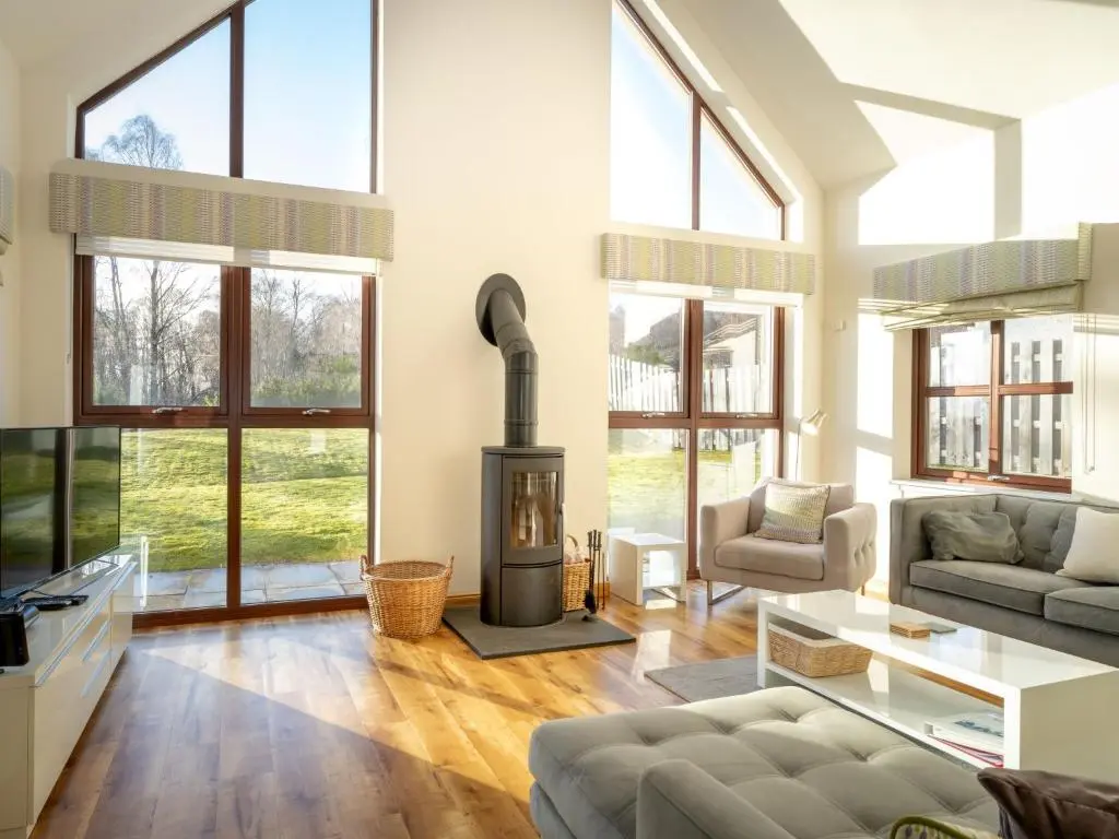 a living room with a fireplace and a couch at Villa Pineways by Interhome in Aviemore